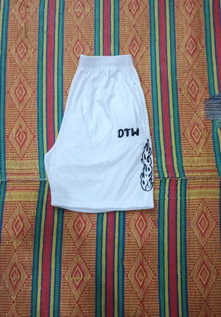 White DTW shorts displayed on a colorful patterned background, featuring a stylish design and comfortable fit.