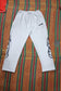 White DTW pants displayed on a colorful woven background, showcasing comfort and style for everyday wear.